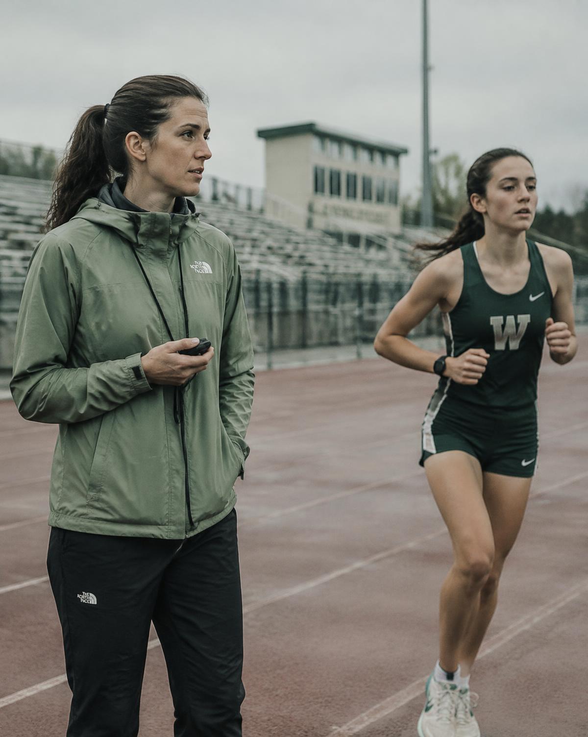 Coach timing a high school girl on the track